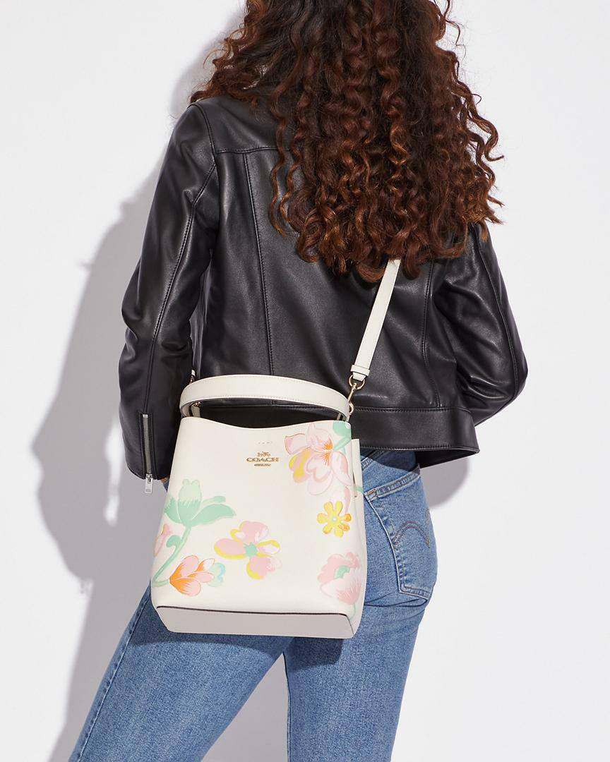 حقيبة "كوتش" (Coach) باكت (Bucket Bag) - بتصميم الزهور الربيعية الأنيق باللون الكريمي