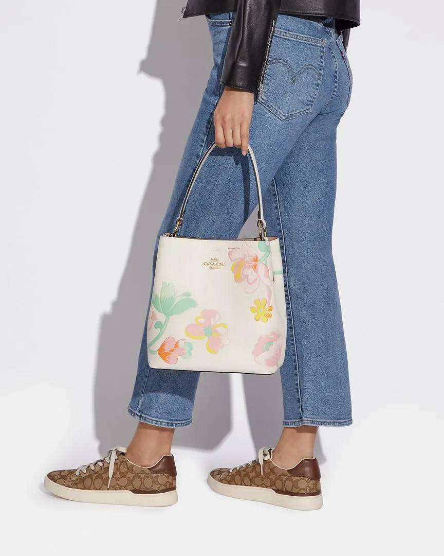 حقيبة "كوتش" (Coach) باكت (Bucket Bag) - بتصميم الزهور الربيعية الأنيق باللون الكريمي